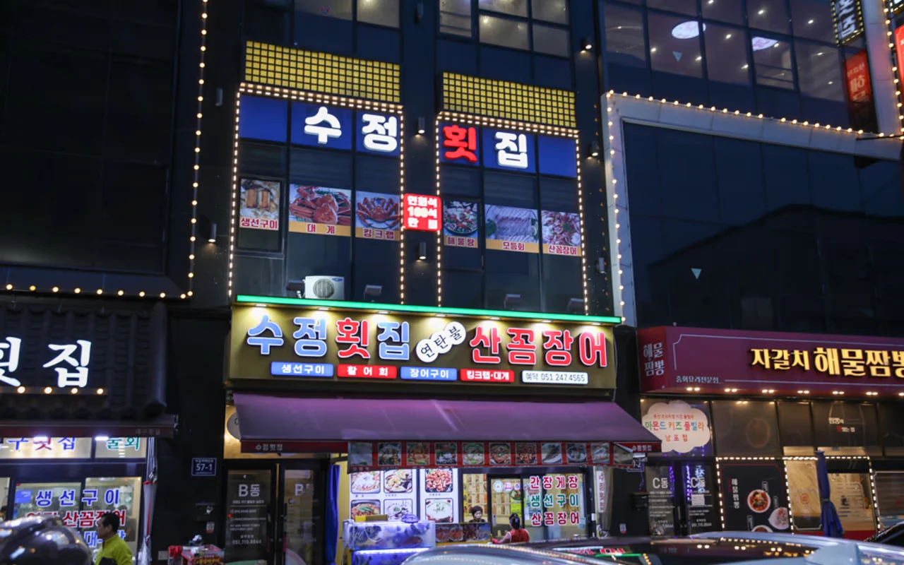 Sujeong Hoejib's nighttime storefront and seafood tanks; photograph date unknown.